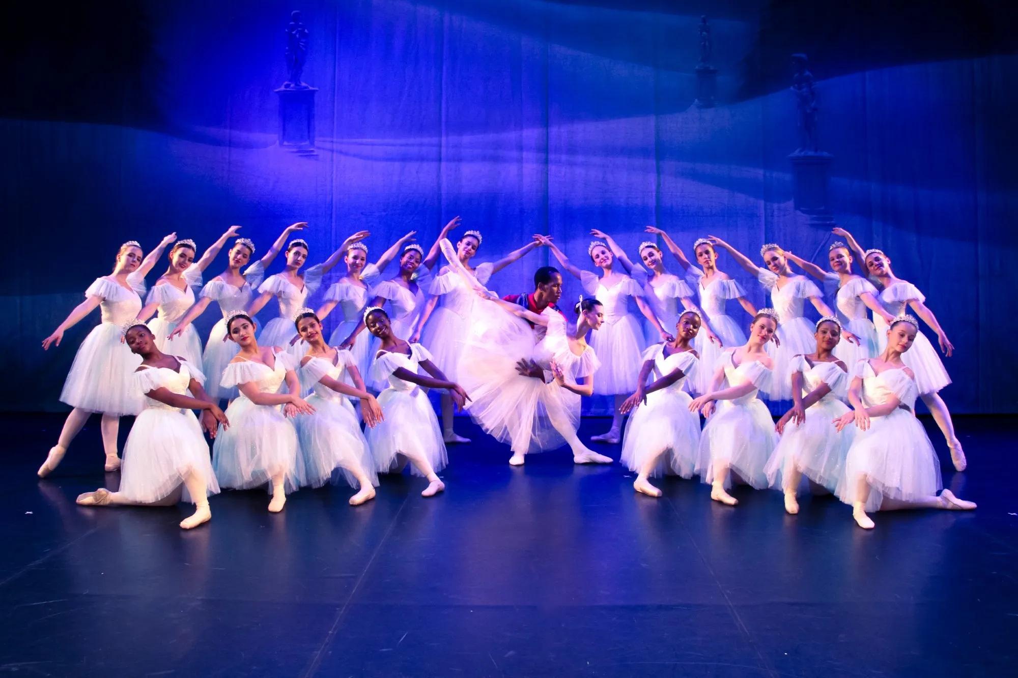 Wide group photo from YRBC's 2023 performance of the Nutcracker. The male and female leads pose in the centre, surrounded by other dancers.